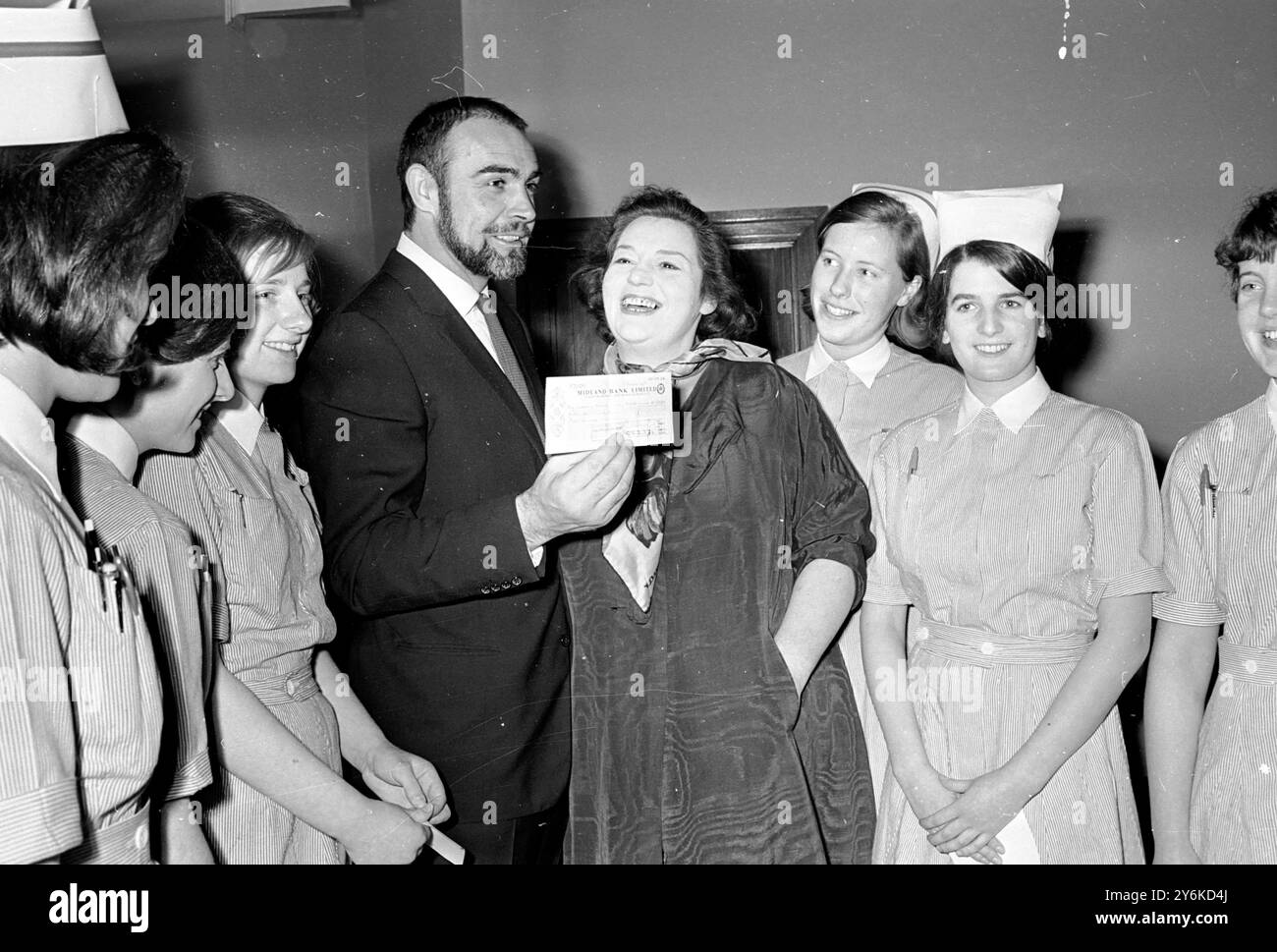 Special Agent 007 James Bond (Sean Connery) stellte mit Miss Hattie Jacques und einigen der Krankenschwestern des Great Ormond Street Hospital für kranke Kinder auf, während der berühmte Schauspieler dem Krankenhaus einen Scheck über 8.000 Pfund überreichte. Die Gelder wurden von der Londoner Niederlassung der Leukämie-Forschung gesammelt, deren Präsidentin Miss Jacques ist. 3. Februar 1966 Stockfoto