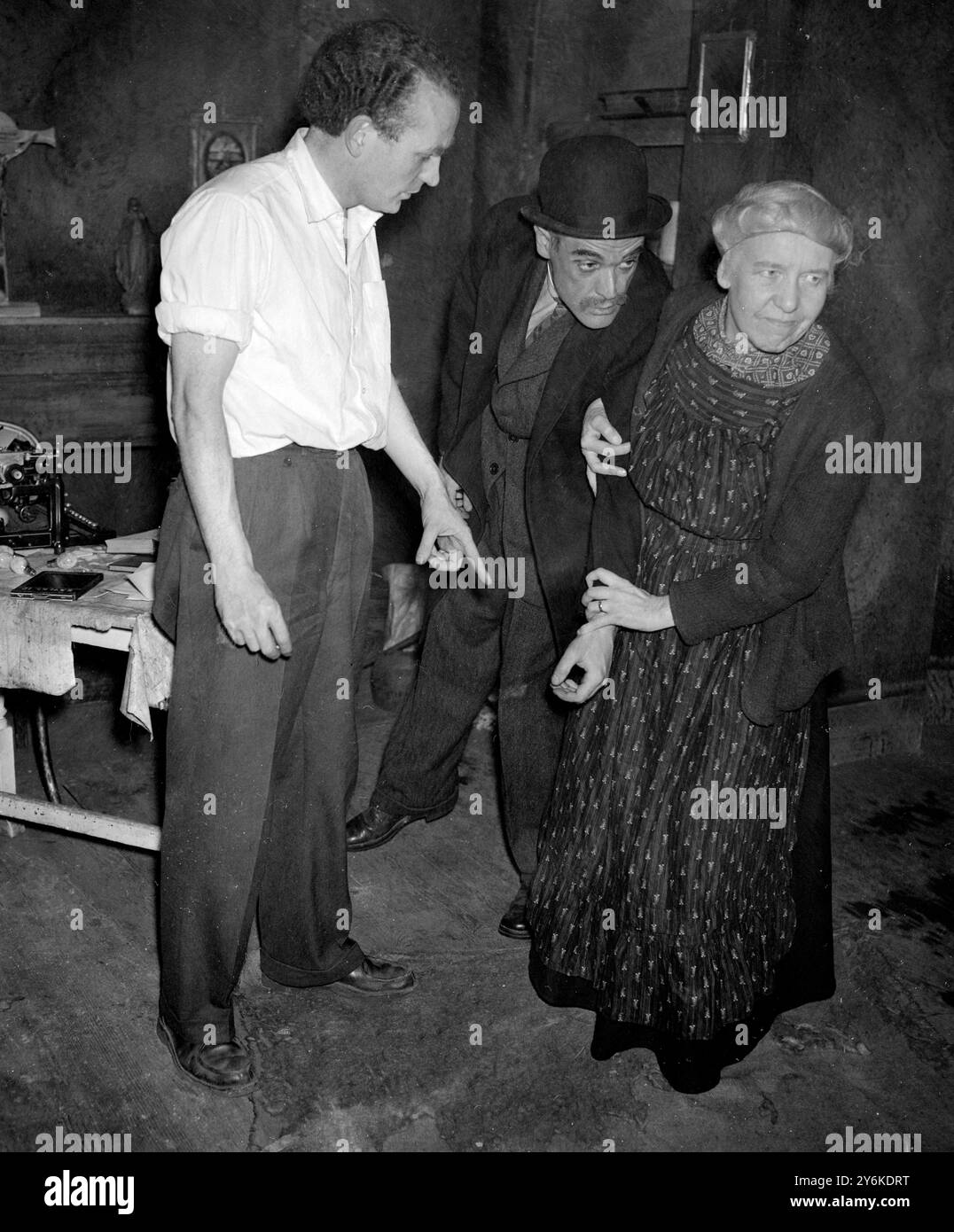 Pat Magee als Mr. Grigson - Sheila Ward als Mrs. Grigson und John Gibson der Produzent während einer Szene aus DEM SCHATTEN Eines SCHÜTZEN von Sean O’Casey, die von den irischen Spielern im New Lindsey Theatre Club, Notting Hill Gate, produziert wurde - 9. Oktober 1956. ©TopFoto Stockfoto