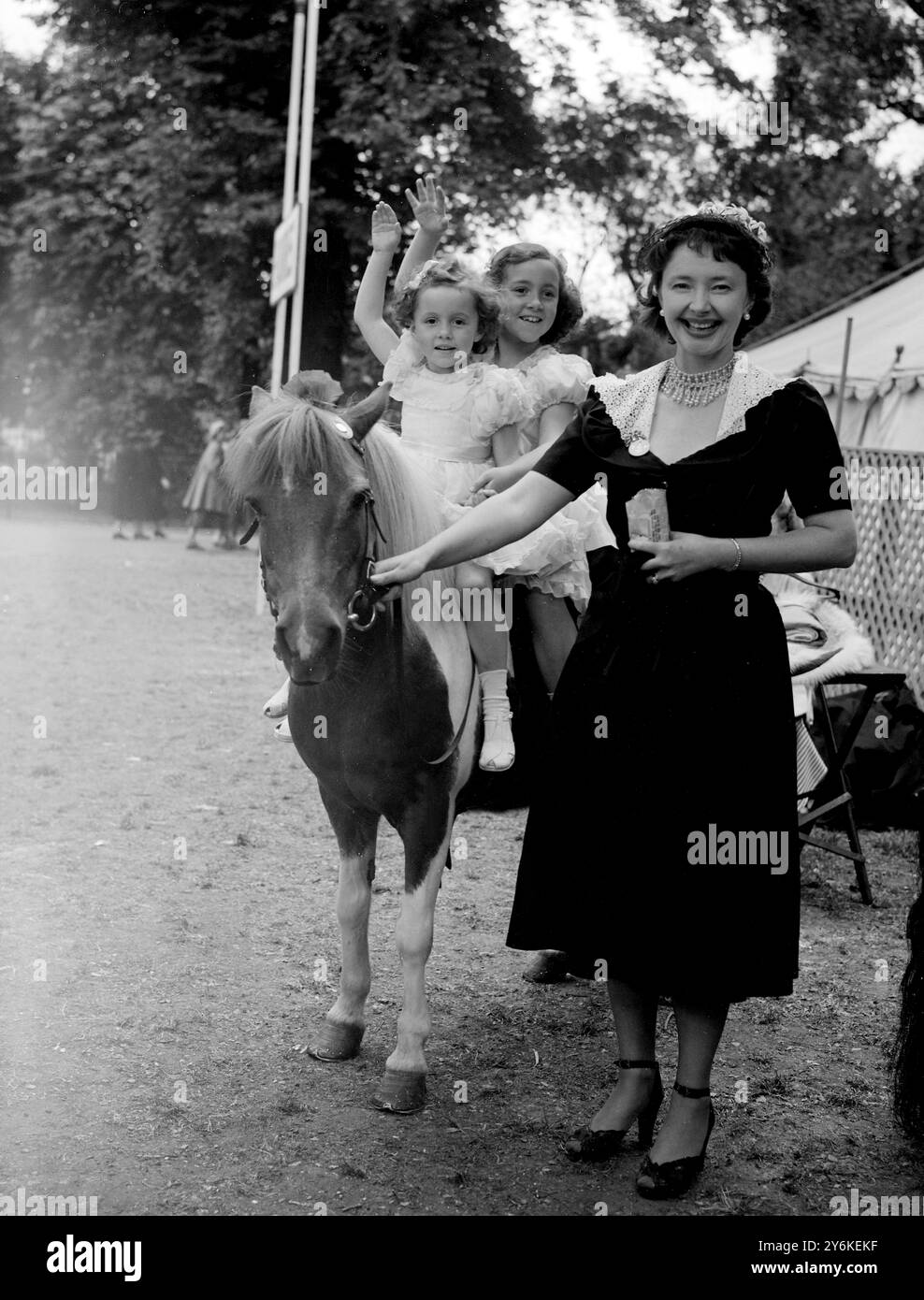 Zwei kleine Mädchen auf einem Pony sind Sylvia (4) und Diana Bebb (7), Töchter von Emlyn Bebb, einer der BBC Singers. Verantwortlich für das Pony ist die Schauspielerin Dulcie Gray. Alles war Teil des Spaßes bei der theatralischen Gartenparty, die am 20. Juni 1951 zu Hilfe des Schauspielerwaisenhauses auf dem Gelände des Royal Chelsea Hospital stattfand. ©TopFoto Stockfoto