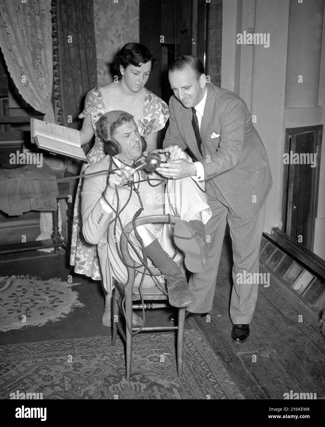 Der Schauspieler Tom Gill wird im Fernsehen festgebunden, als BBC-Kommentator Brian Johnson ihm während der Proben in der Comedy The Happy Family ein paar Ratschläge gibt. - 20. Juni 1951. Stockfoto