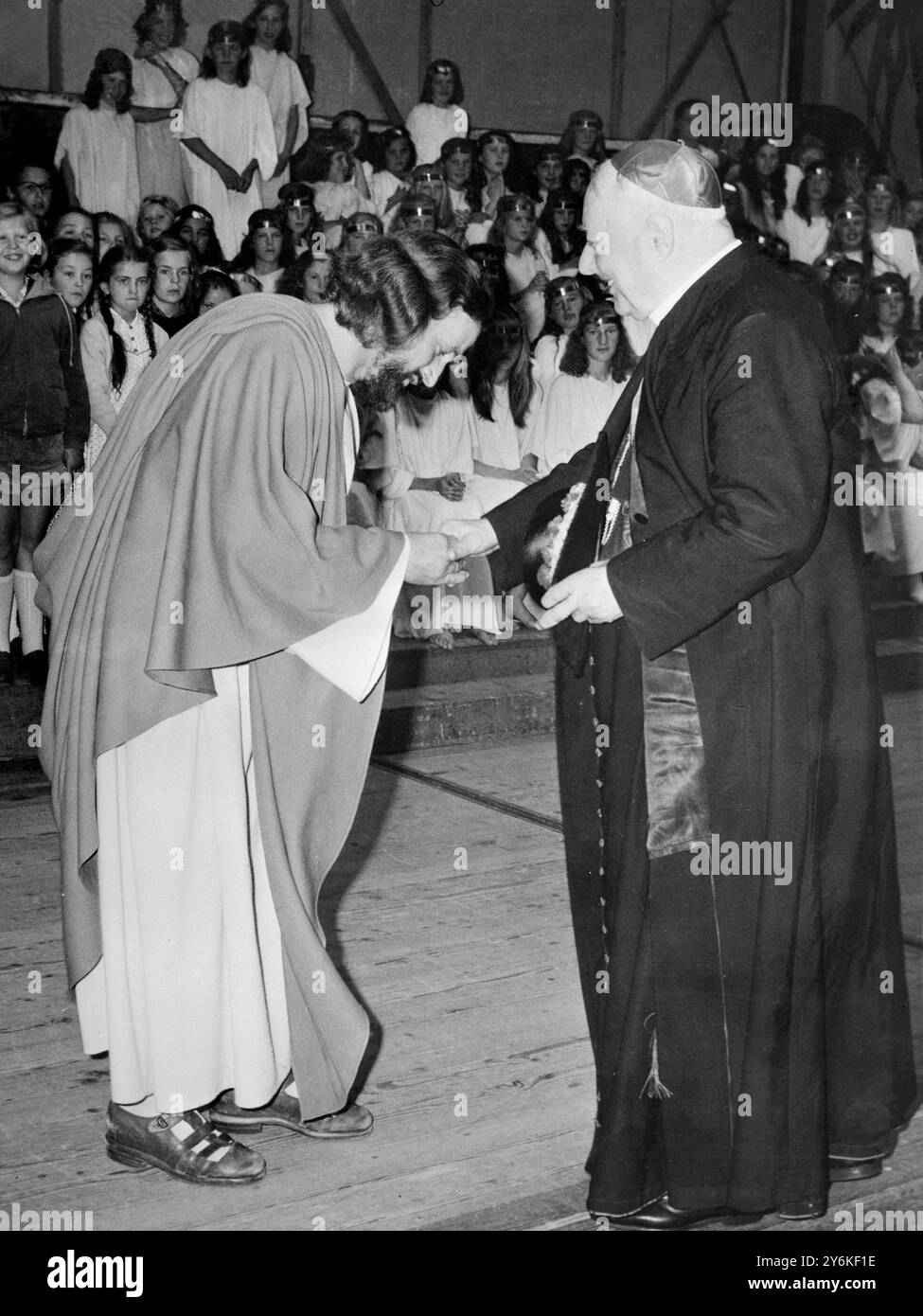 Noch in Kostümen beugt sich Anton Presinger , der Christus im Passionsspiel darstellt , um die Hand des päpstlichen Legaten Gustavo Kardinal Testa zu küssen , während dieser nach dem Besuch des Passionsspiels hinter der Bühne aufsucht . Der Kardinal war in Deutschland als Vertreter von Papst Johannes auf dem 37. Eucharistischen Weltkongress in München tätig. 3. August 1960 Stockfoto