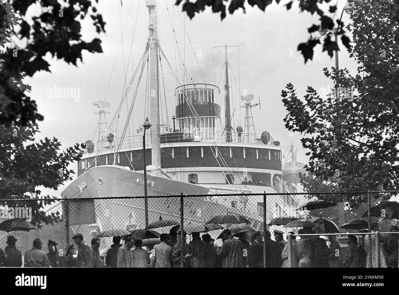 Baltika kommt im Regen an – 19. September 1960 kommunistische Streikposten, die im strömenden Regen unter Regenschirmen geschützt sind und den sowjetischen Liner Baltika betrachten, als sie am Pier 73 im New Yorker Hafen gefesselt war. An Bord waren der sowjetische Premierminister Nikita Chruschew und andere kommunistische Führer, die an der UN-Generalversammlung in New York teilnahmen. Quelle: www.TopFoto.co.uk Stockfoto