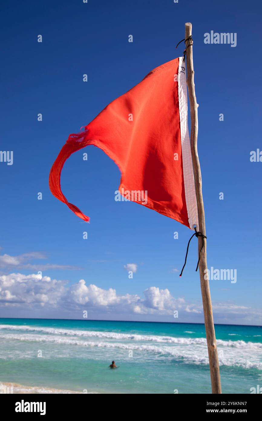 Mann, der vor einer roten, nicht badenden Flagge schwimmt Stockfoto