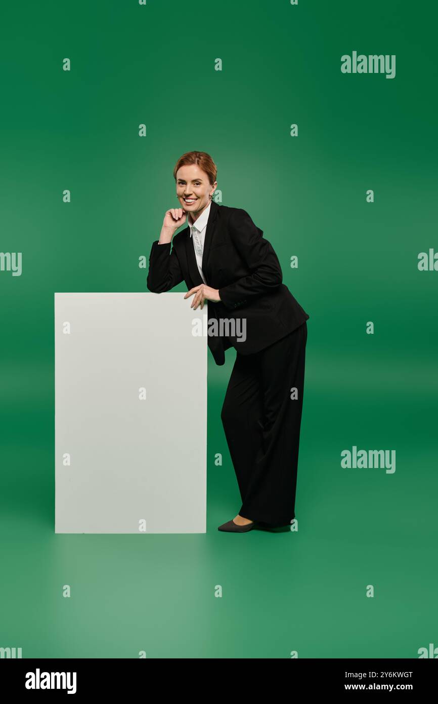 Ein stilvoller Fernsehmoderator posiert anmutig in einem professionellen Outfit Stockfoto