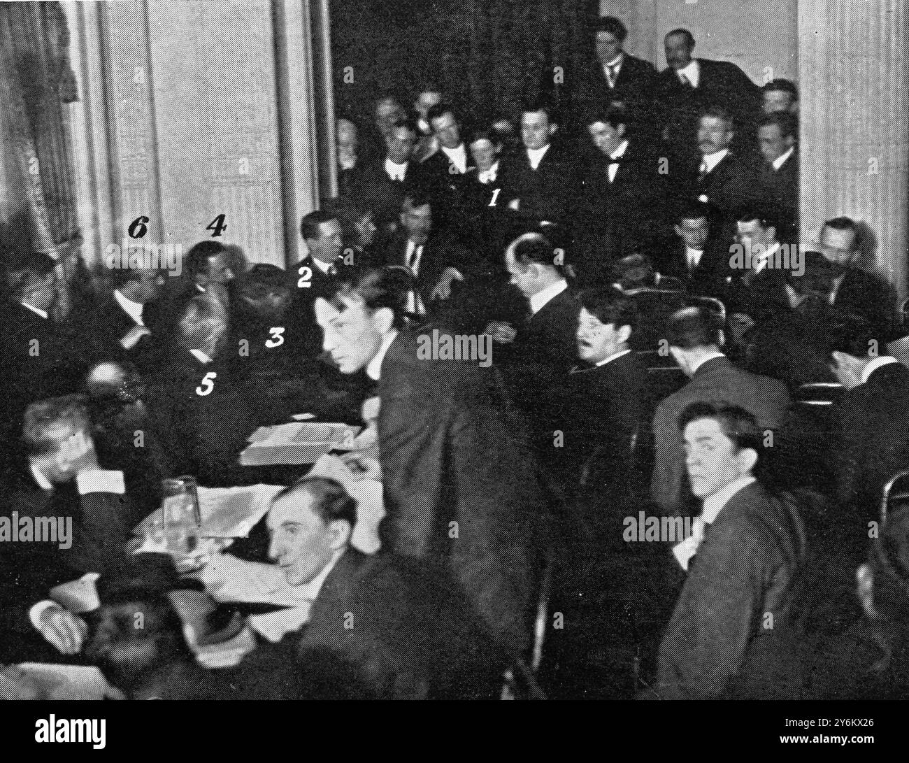 Auf der anderen Seite: "Titanic"-Katastrophenüberlebende in New York. Vor Senator Smith, in den früheren Phasen der senatorischen Untersuchung: Die Kommission hört Zeugen im Ballsaal des Waldorf-Astoria Hotel New York zu. Abbildungen auf Foto Nr. 1. Herr Cottam, drahtloser Betreiber der "Carpathia"; Nr. 2. Signor Marconi; Nr. 3. Vertreter Hughes; Nr. 4. Herr Bruce Ismay; Nr. 5. Senator Smith; Nr. 6. Herr Franklin. 4. Mai 1912 4. Mai 1912 Stockfoto