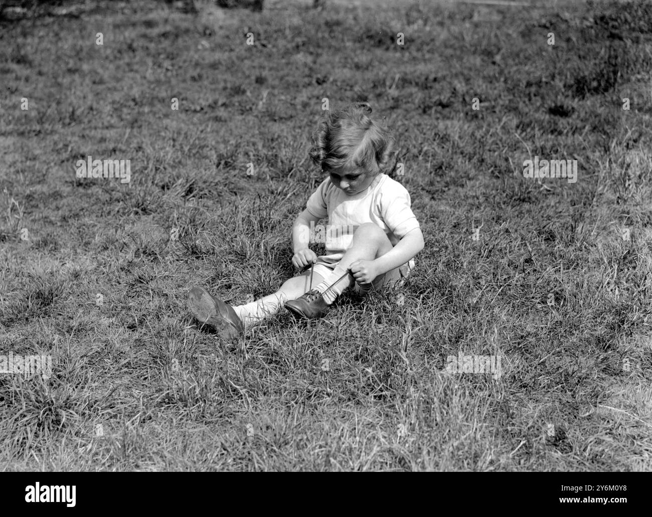 Buxted Lodge, Clapham, Süd-London. Kindergarten, kleines Mädchen, das auf dem Gras sitzt. 25. Mai 1927 Stockfoto