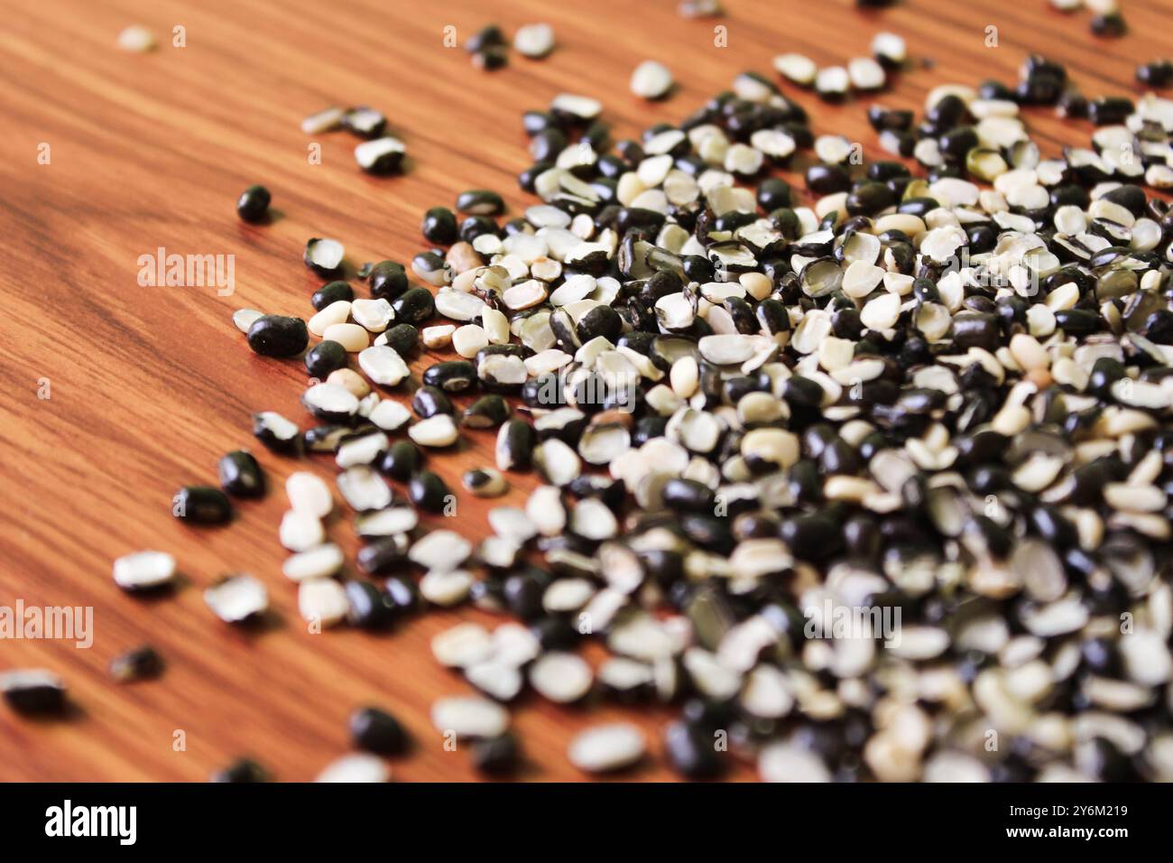 Split Black Linse auch bekannt als Black Gram, Black urad Dal, Vigna Mungo, urad Bean auf braunem hölzernem Hintergrund Stockfoto