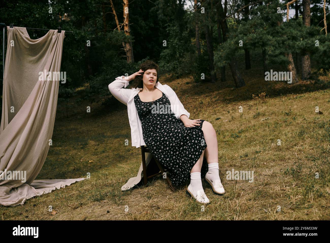 Eine fröhliche Frau in Übergröße entspannt sich in einem üppigen Feld und genießt die Schönheit der Natur. Stockfoto