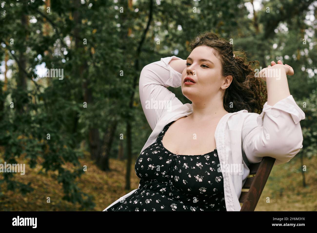 Eine hübsche Frau in Übergröße genießt die Ruhe eines Feldes in der Natur. Stockfoto