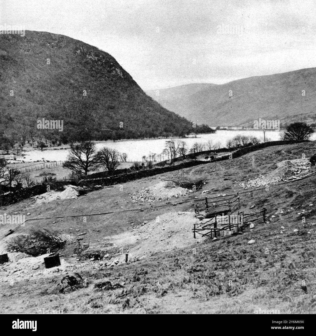 Ein Lakeland „Philae“: Mardale – Ein Dorf, das durch die Vertiefung von Haweswater als Reservoir für Manchester untergetaucht werden soll. Haweswater: Der heutige See mit Bohrungen auf der Suche nach geeigneten Substraten, auf denen ein Damm gebaut werden kann - (im linken Hintergrund) Walla Crag und Naddle Forest, ein Rückzugsort von Raben. 6. Juli 1929 Stockfoto