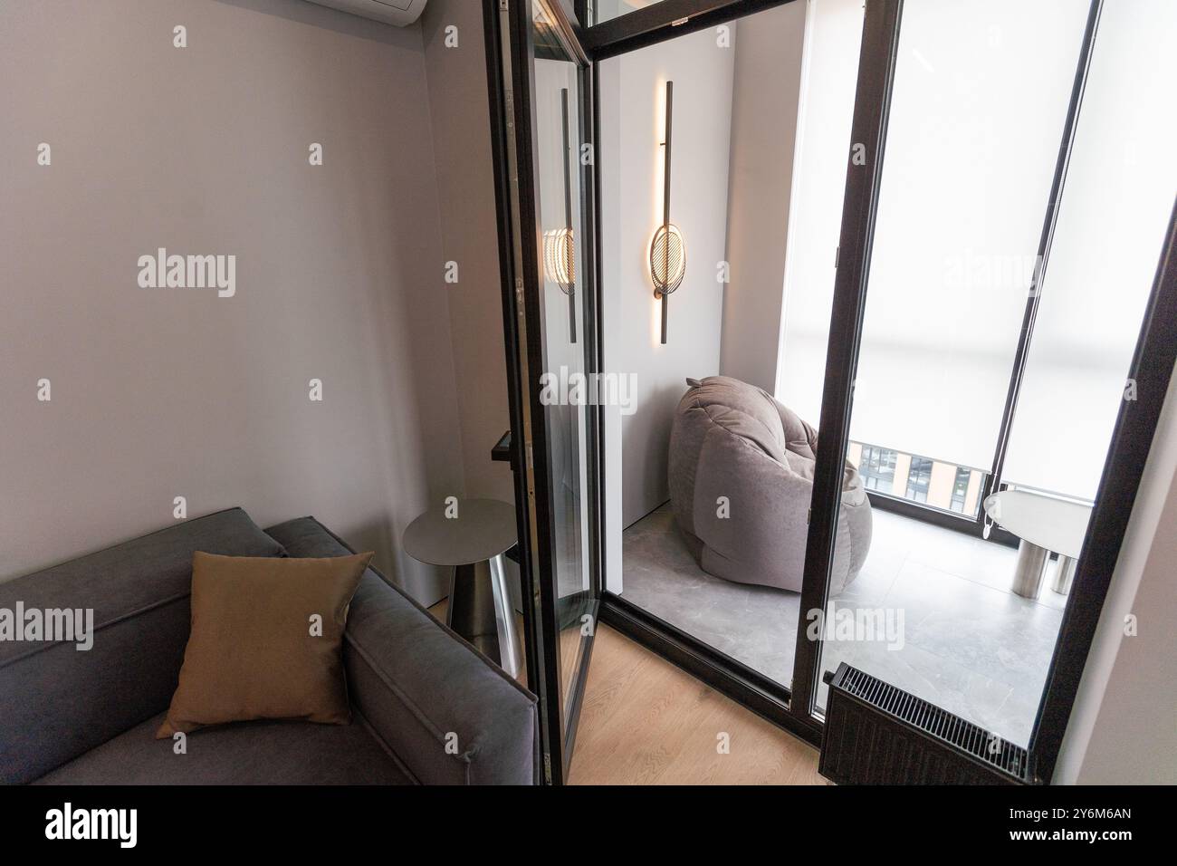 Ein kleines Wohnzimmer mit Sofa auf Laminatböden in einem modernen Haus Stockfoto