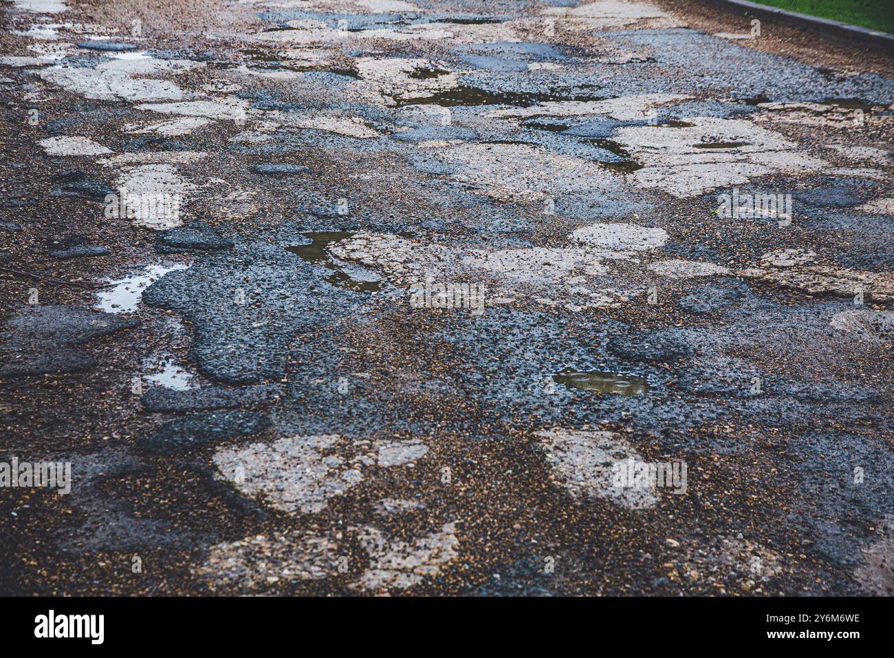 Englische Straße mit Schlaglöchern und Bitumenreparatur Stockfoto
