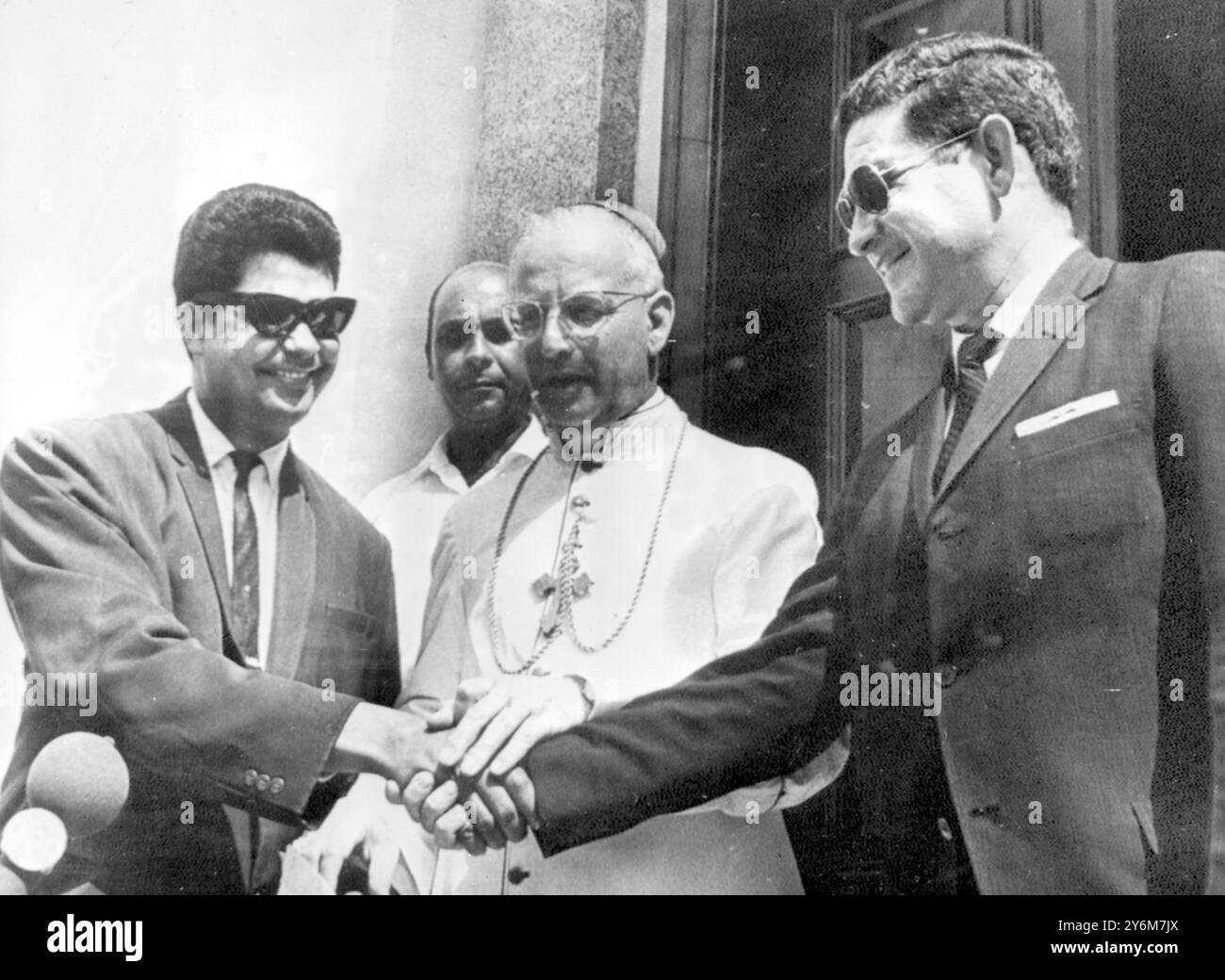 Santo Domingo, Dominikanische Republik: Erste Begegnung mit beiden Seiten des Dominikanerstreits gestern, außerhalb der Residenz des päpstlichen Nuntius, Emanuele Clarizio (Mitte). Links ist Hector Conde, Vertreter der Rebellen, und rechts ist Generalleutnant Milton Subervi, Mitglied der Militärjunta, dargestellt, nachdem sie eine Vereinbarung unterzeichnet hatten. Nach 40 Stunden Gesprächen mit den Gegenparteien berichtete Eine Friedensmission der Organisation amerikanischer Staaten von Fortschritten in Richtung eines Waffenstillstands und dass beide Seiten die Bezeichnung eines vom Komitee vorgelegten Befriedungsvorschlags akzeptiert hatten. 5. Mai 1965 Stockfoto