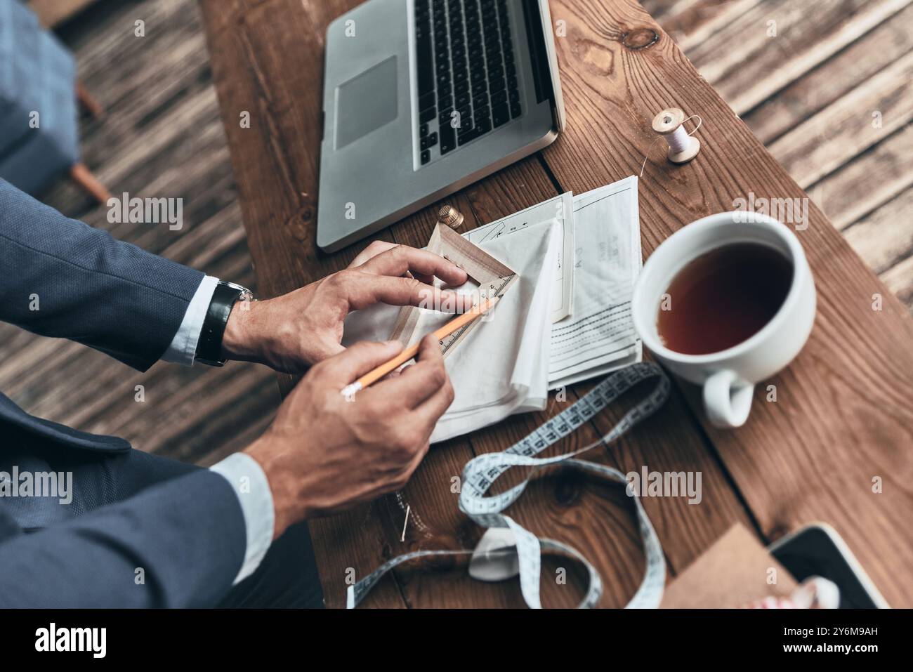 Konzentriert auf die Arbeit. Nahaufnahme des Modedesigners, der während seiner Arbeit im Designstudio Skizzen erstellt Stockfoto