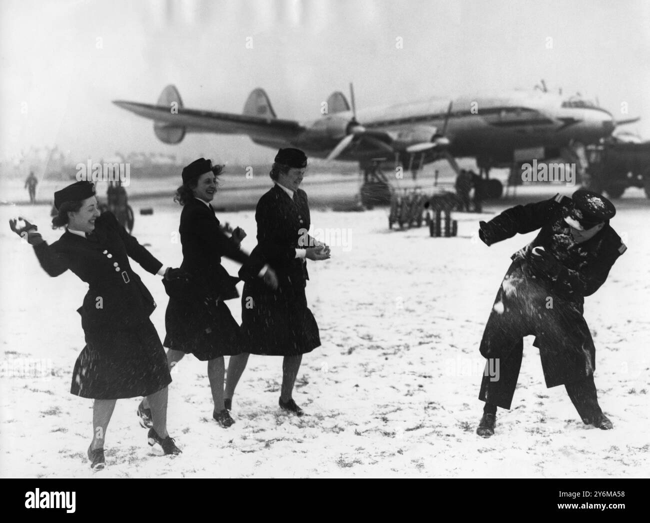 Angriff auf niedriger Ebene! Der Tiefschnee am Flughafen London (Heathrow) brachte die Flüge zum Stillstand. Hier attackiert eine Gruppe von BOAC-Flughostessen den stellvertretenden Superintendent der Station in der Mittagsstunde. 30. Januar 1947 Stockfoto