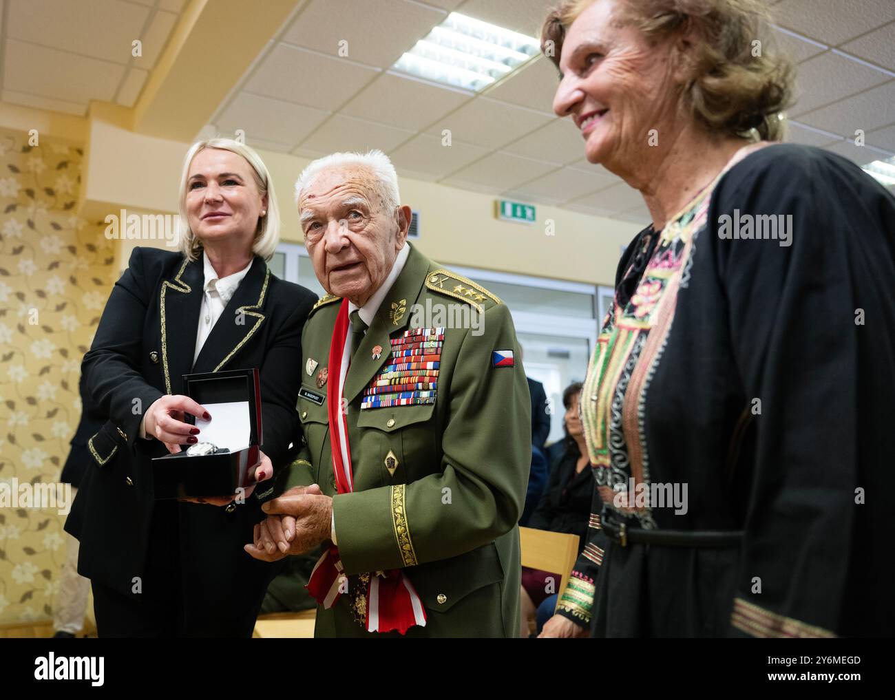 Jince, Tschechische Republik. September 2024. Der tschechische Kriegsveteran Miloslav Masopust (Mitte), das letzte überlebende Mitglied eines Artillerieregiments des 1. Tschechoslowakischen Armeekorps, trifft am 26. September 2024 in Jince, Tschechien, auf die tschechische Verteidigungsministerin Jana Cernochova (links). Masopust wird 100 Jahre alt. Auf der rechten Seite ist Masopusts Frau Helena Masopustova zu sehen. Quelle: Michaela Rihova/CTK Photo/Alamy Live News Stockfoto