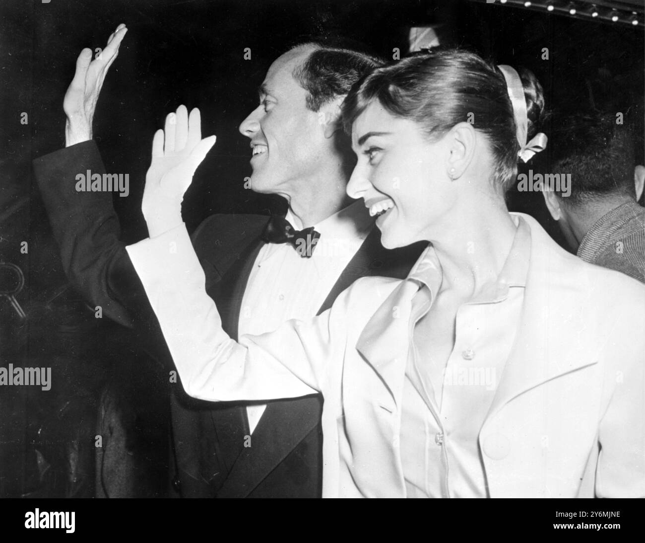 New York: Die mit der Akademie ausgezeichnete Schauspielerin Audrey Hepburn und ihr Mann Mel Ferrer, die die Dreharbeiten „Krieg und Frieden“ beendet haben, kommen im Capital Theatre zur Weltpremiere von „Guys and Dolls“ an. 5. November 1955 Stockfoto