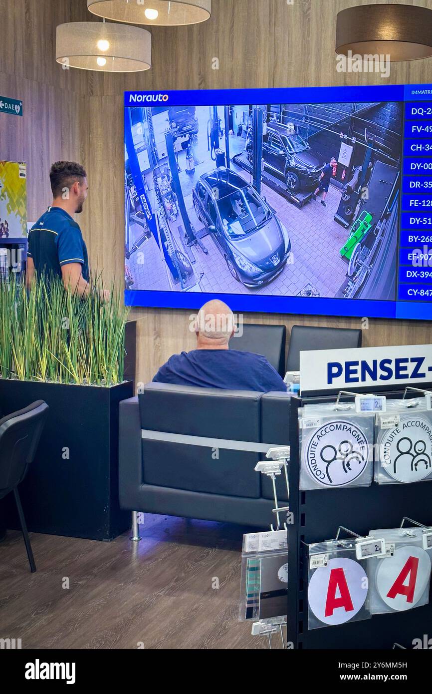 Live-Übertragung von Kameras in der Werkstatt einer Marke Norauto mit Wartebereich für Kunden Stockfoto