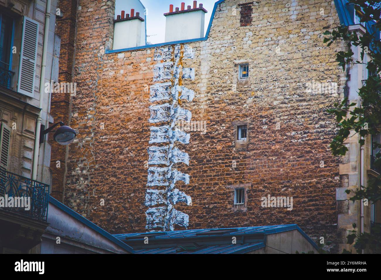 Frankreich, Paris. Street Art, Spine an einer Backsteinmauer auf der Rückseite eines Gebäudes Stockfoto