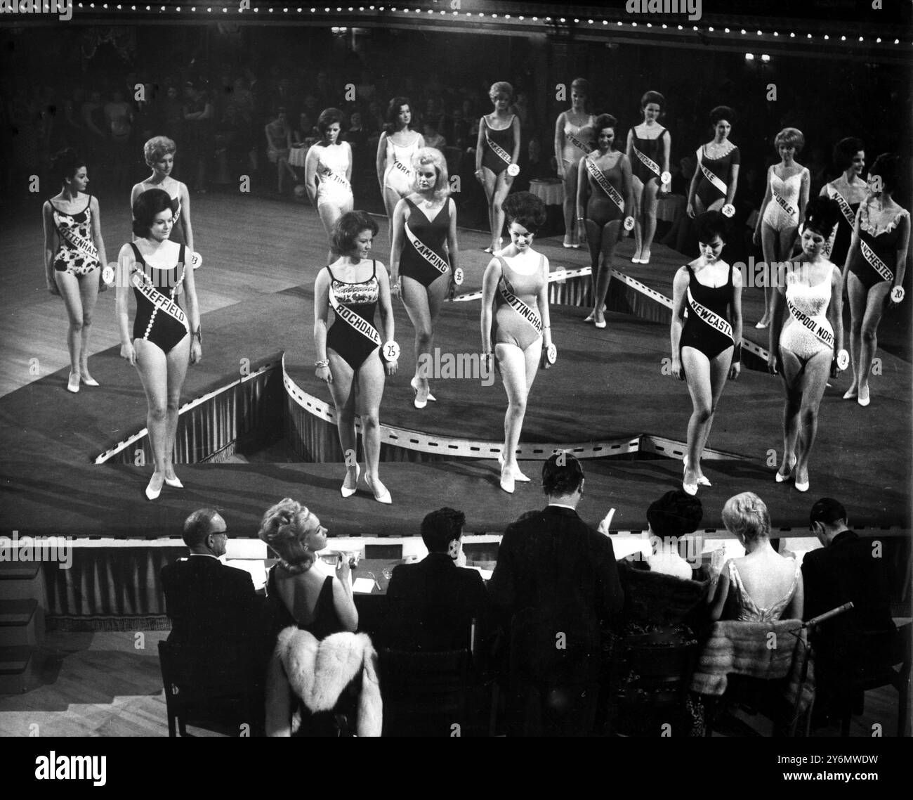 Teilnehmer, die in Badeanzügen vor den Richtern beim Miss England 1964 Wettbewerb im Ritz Ballroom in Manchester parieren. Stockfoto