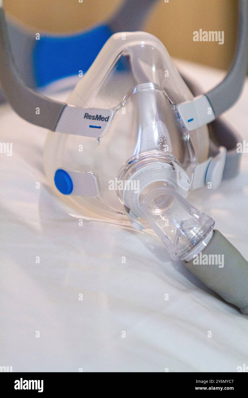 Stillleben einer Maske auf einem Bett, um Schlafapnoe zu behandeln Stockfoto