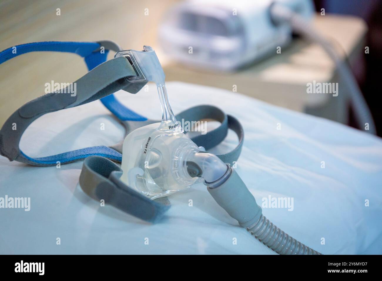Stillleben einer Maske auf einem Bett, um Schlafapnoe zu behandeln Stockfoto