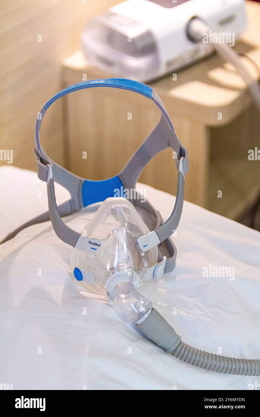 Stillleben einer Maske auf einem Bett, um Schlafapnoe zu behandeln Stockfoto