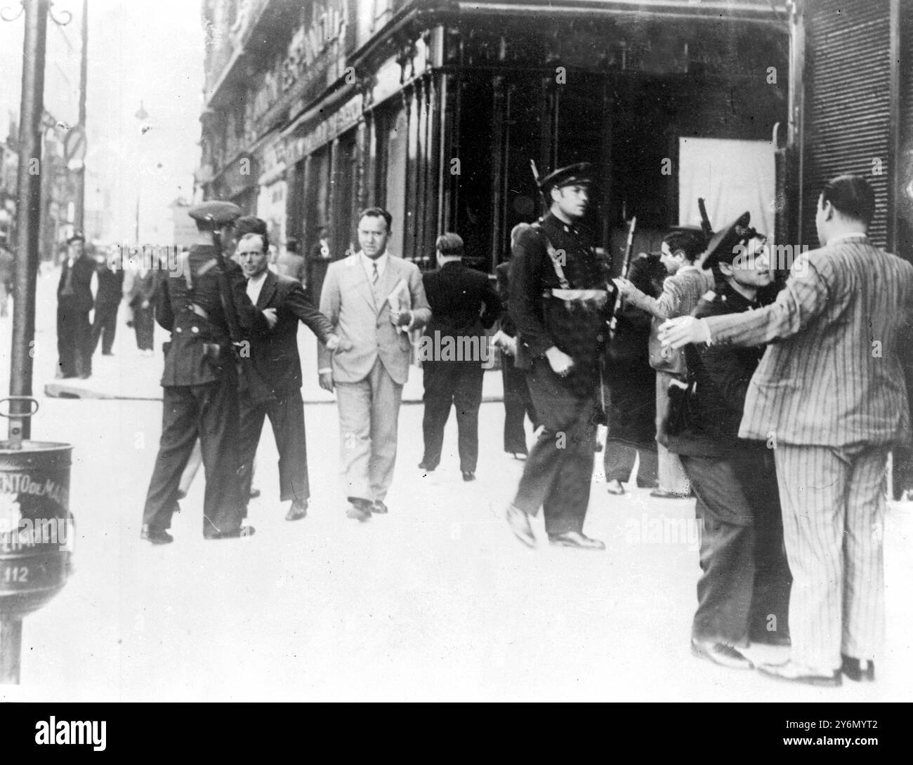 Einige der gravierendsten Aspekte des Chaos, das durch den spanischen Bürgerkrieg entstanden ist, ist die Tatsache, dass Madrid ist praktisch ohne Nahrung - Revolutionäre haben die Vorräte an die Hauptstadt abgeschnitten - lange Warteschlangen warten ständig draußen die Geschäfte in der Hoffnung etwas zu essen zu bekommen - Foto zeigt bewaffnete Polizei sucht Fußgänger in Madrid - diejenigen, die Anzeichen zeigten, dass sie versuchen, der Untersuchung zu entgehen, wurden ohne Bescheid erschossen 10. Oktober 1934 Datei Stockfoto