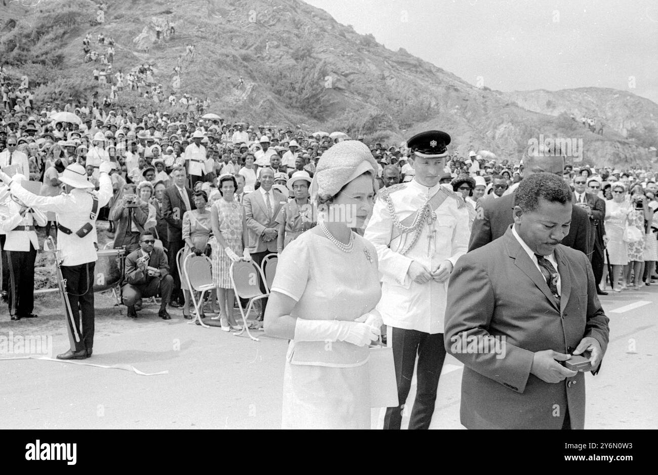 Barbados : die britische Königin Elizabeth II. Schneidet das Band ab, um die New kostspielige East Coast Road an der malerischen Küste der Gemeinde St. Andrew zu eröffnen. Auf der rechten Seite befinden sich Herr Alwyn Wason, Direktor für Autobahnen und Verkehr in Barbados, und Herr Neville Boxill, Minister für Kommunikation. Die Königin und Prinz Philip Duke of Edinburgh waren auf einem zweitägigen Besuch der Insel im Rahmen ihrer aktuellen 5-wöchigen Tour durch die Karibik commonwealth Territorien. 17. Februar 1966 Stockfoto