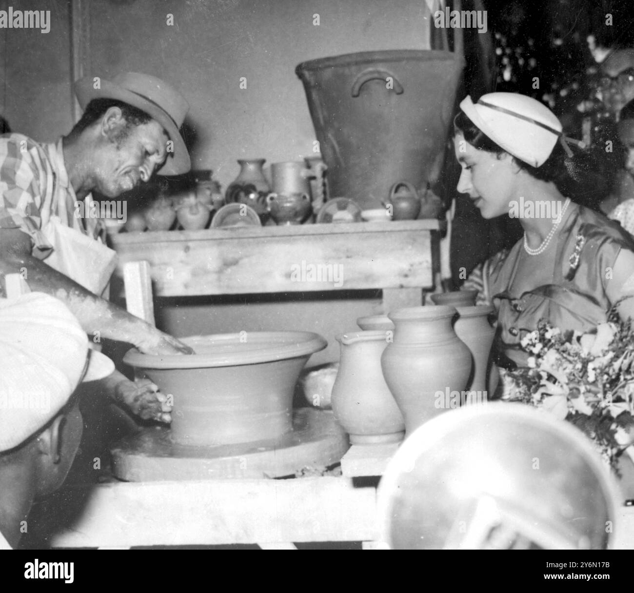 Barbados: Prinzessin Margaret sieht fasziniert, wie ein Topf an einem lokalen Handwerksstand auf der Barbados Trade and Industries Fair hergestellt wird, die sie während ihres Aufenthalts auf dieser Insel besuchte. Februar 1955 Stockfoto