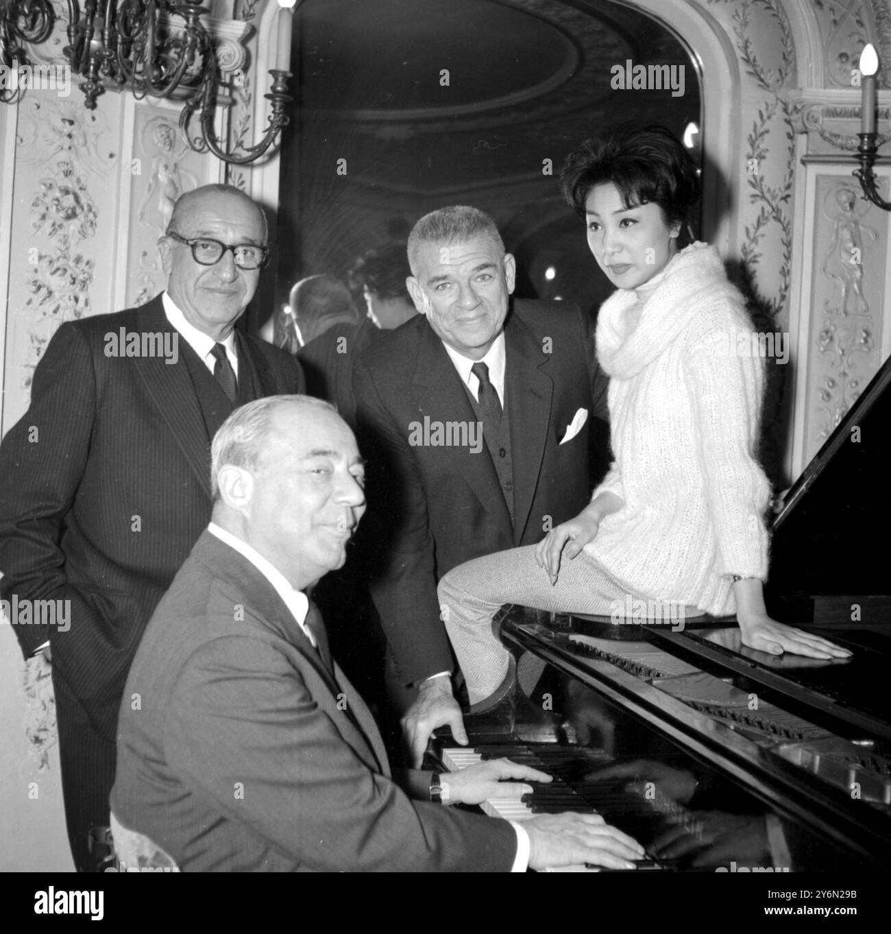 London: Richard Rodgers sitzt am Klavier, und seine Partner Oscar Hammerstein II. Stehen hinter ihm, mit Joe Fields Co-Autor des Musicals „Flower Drum Song“, und Yau-Shantung, 20, der eine der Hauptrollen des Musicals spielt, während sie heute Morgen im Palace Theatre ein Treffen veranstalten. Rodgers und Hammerstein II. Sind gestern Abend aus New York geflogen, um an den Proben ihres orientalischen Musical-Hits teilzunehmen, der am 24. märz eröffnet wird. März 1960 Stockfoto