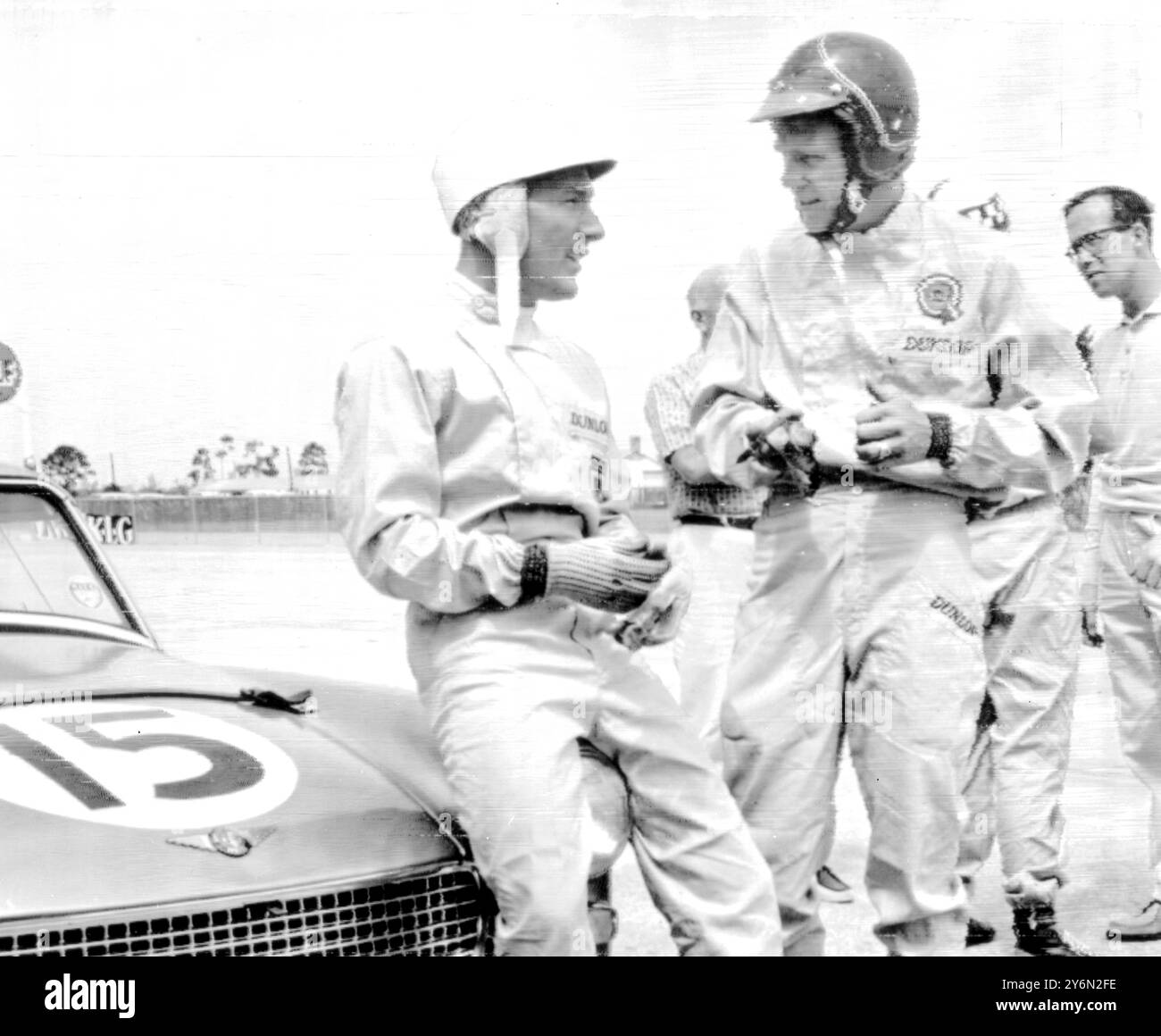 Sebring, Florida USA: Die British Motor Corporation hat ein experimentelles 110-M.H.-Auto am Samstag in Sebring 12-Stunden-Langstreckenrennen mit Hollywood-Film Star Steve McQueen (rechts) am Lenkrad gestartet. Hier spricht der britische Rennfahrer Stirling Moss (links) über sein internationales Renndebüt und moss fährt Austin Healey Sprites arte Mitglieder des British Motor Corporation Team Steve McQueen ein Star des Westernfilms The Magnificent Seven, der letztes Jahr in Großbritannien gefahren wurde, als er einen neuen Film drehte: Der war Lover. Sein Beifahrer wird am Samstag John Colgate von der amerikanischen Zahnpasta-Familie sein. Stockfoto