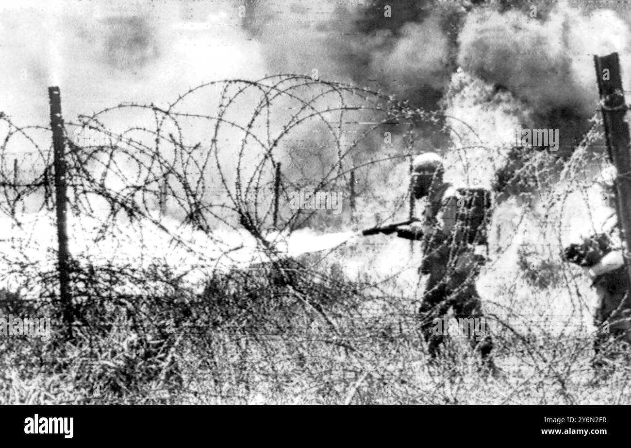 Khe Sanh, Südvietnam: Ein amerikanischer Marine verbrennt gestern Gras und Unterholz und jeden versteckten Feind mit glühenden Sprengungen von seinem Flammenwerfer am Rand der Festung. Heute ist der 14. Jahrestag des Beginns der Schlacht von Dien Bien Phu. 13. März 1968 Stockfoto