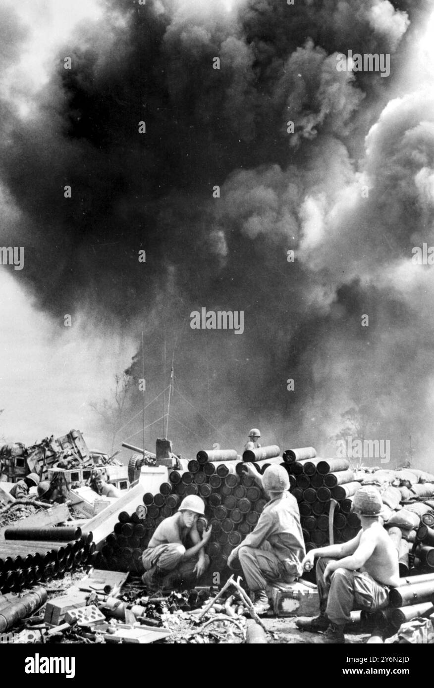 DAK nach Südvietnam: Amerikanische Truppen halten den Kopf nach unten, während eine Munitionsdeponie in Dak in riesigen Rauchschwaden aufgeht, nachdem sie von nordvietnamesischen Mörsern getroffen wurden. Es war das dritte Mal, dass die Deponie in der nun 20 Tage alten Schlacht im zentralen Hochland getroffen wurde. Berichten zufolge wurden 157 Amerikaner und 1.120 Vietnamesen in der Schlacht getötet. 22. November 1967 Stockfoto