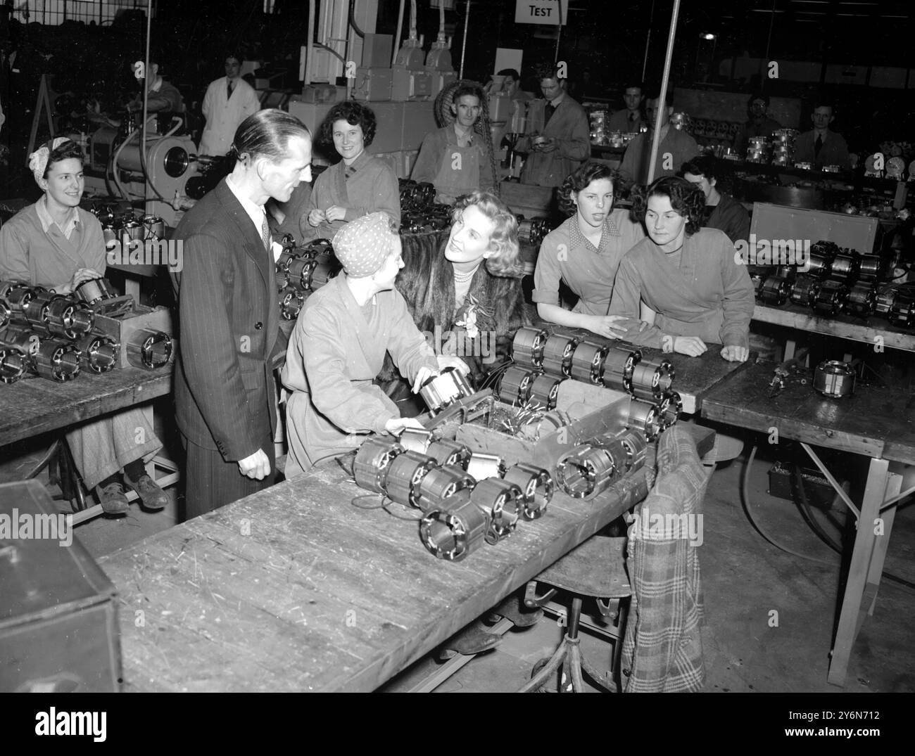 Ex-Bergmann Daniel Bowen (links), der die Fabrik eröffnete, und Ann Crawford (im Pelzmantel) unterhielten sich mit einigen der lokalen Mädchen, die bereits in der Welsh Hoover Factory in Merthyr Tydfil, Glamorgan, arbeiten. - Stockfoto