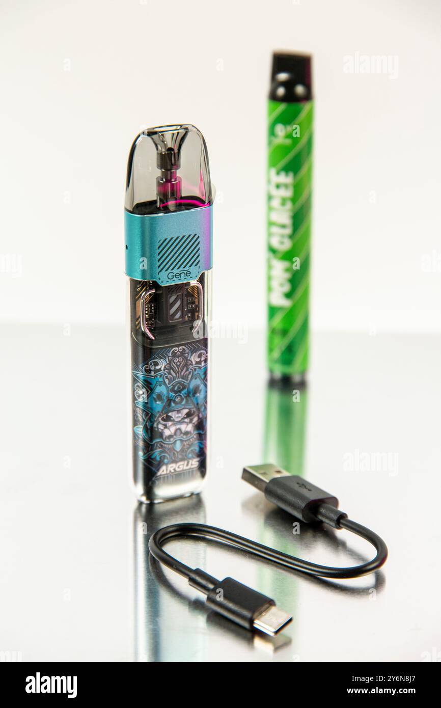 Stillleben zum Thema Zigarettenersatzprodukte. Pod oder Pod-mod.. Im Hintergrund ein Puff, eine kleine elektronische Zigarette Stockfoto
