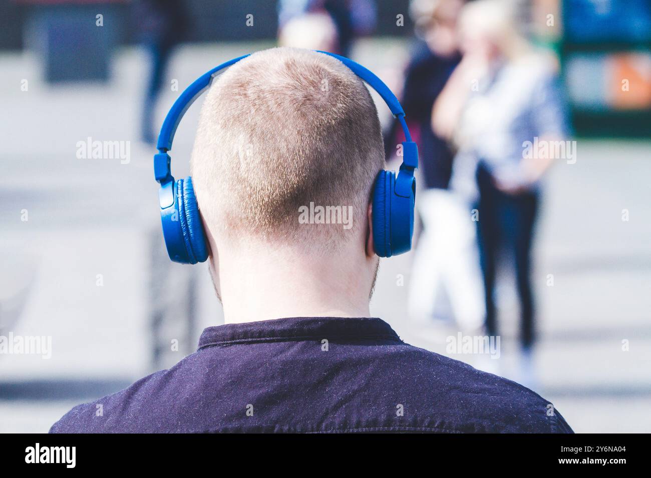 Mann von hinten, der Kopfhörer im Stadtzentrum trägt Stockfoto