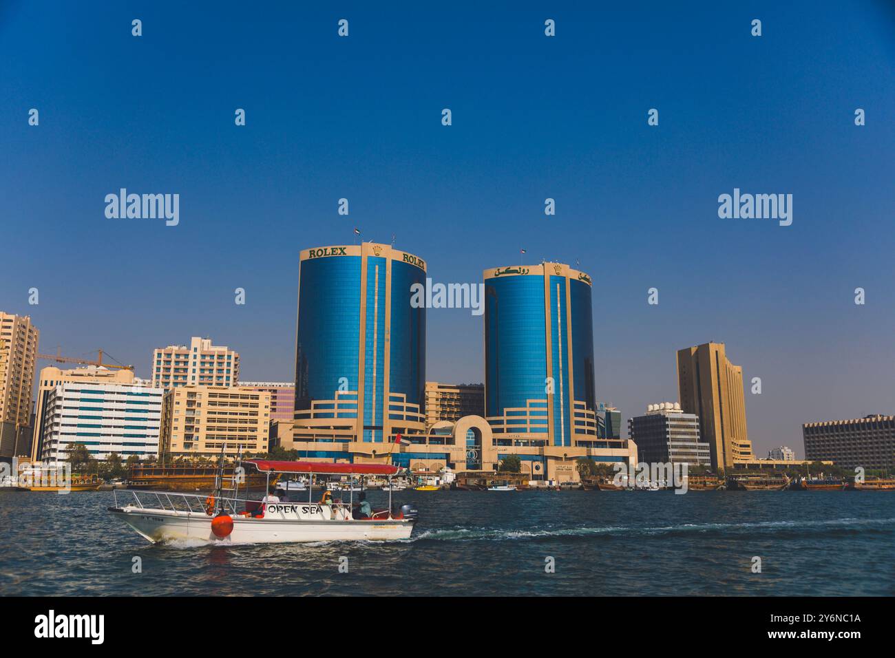 Vereinigte Arabische Emirate, Dubai, Deira. Bur Dubai. Abra, Taxiboot am Khor Dubai Inlet. Zwillingsturm Deira kommentiert den Bericht Stockfoto