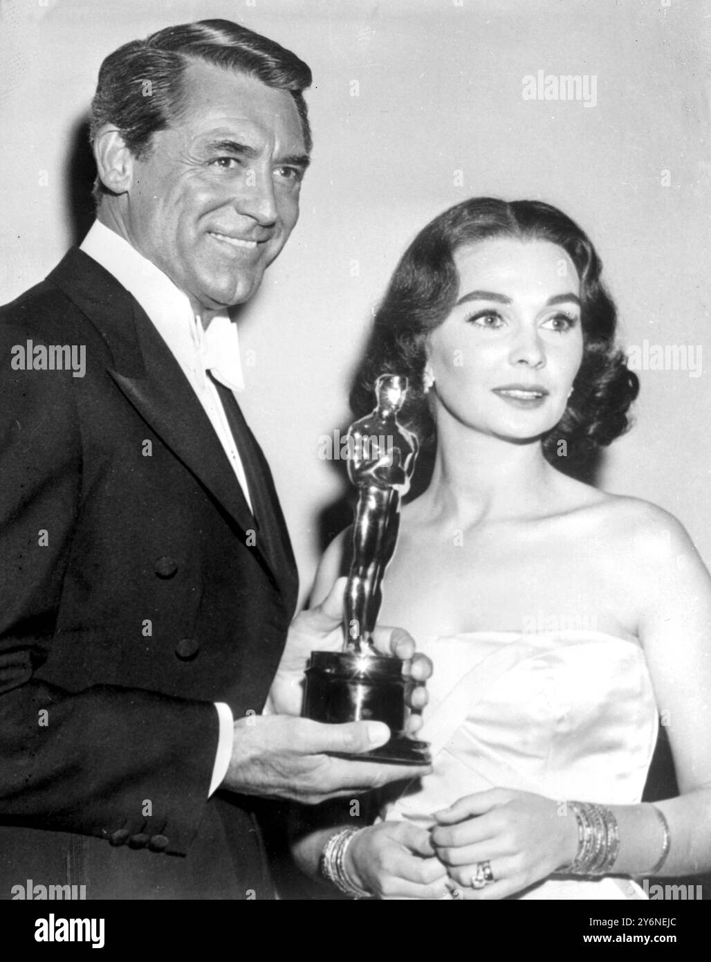 Hollywood: Schauspieler Cary Grant überreicht den Preis „Bester Schauspieler des Jahres“ an Jean Simmons, der ihn im Namen des britischen Schauspielers Alec Guinness entgegennimmt. Guinness erhält den Preis für seine Rolle in dem Film „die Brücke am Fluss Kwai“. 27. März 1958 Stockfoto