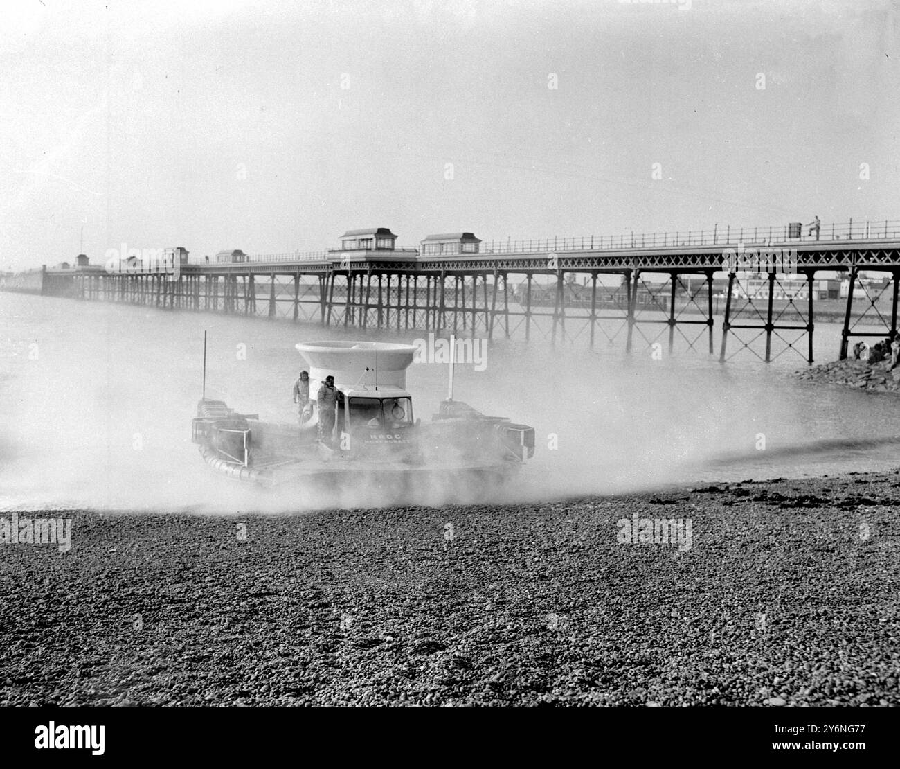 Dover, Kent: Die britische Hovercraft, die SR-N 1 fliegende Untertasse, spritzt einen feinen Spritzer Salzwasser auf, als sie heute Morgen den Strand von Dover hochkommt. Nachdem sie mit einem 10-Zoll-Luftkissen von Calais über den Kanal geflogen war, machte die SRN 1 die Reise in zwei Stunden und drei Minuten. Mit Testpilot, Lieut Commander Peter Lamb, Erfinder Christopher Cockerell und Flugbeobachter John Chaplin krabbelten sie während des 21-Meilen-Fluges als beweglicher Ballast über das offene Deck. 25. Juli 1959 Stockfoto