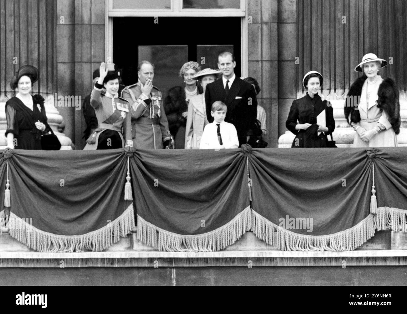 Die einstündige Zeremonie ist vorbei, der Herzog von Gloucester raucht eine Zigarette, während seine Nichte, Königin Elisabeth II., fröhlich vor den Toren des Buckingham Palace winkt, nachdem er die Farbe von links nach rechts Trooping: Die Königin Mutter, die Königin, der Herzog von Gloucester, die Marchioness von Carlsbrooke, die Prinzessin Royal der Herzog von Edinburgh und vor Prinz Richard von Gloucester, Prinzessin Margaret von Gloucester, Prinzessin Margaret und Lady Patricia vom 5. Juni 1952 Stockfoto