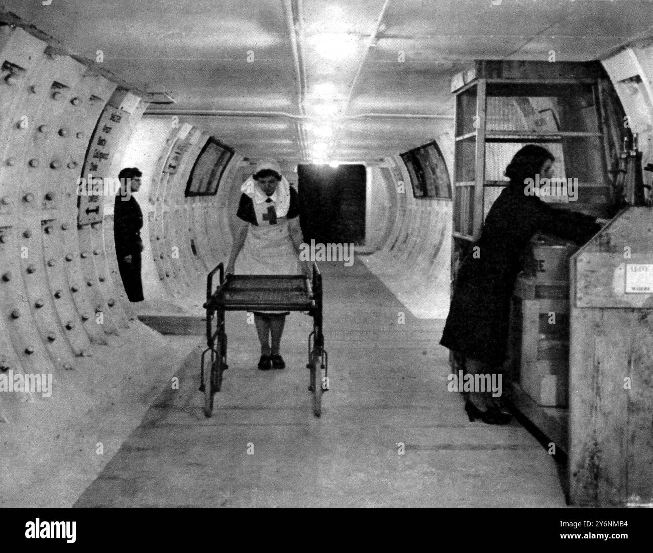 Londons Mammut-Schutzhütten. Die Eingangshalle eines Tierheims mit einer roten Kreuzschwester mit einer Bahre für Behinderte und diensthabende Wärterinnen. Jedes hat eine Krankenhausunterkunft mit Ärzten Krankenschwestern und Krankenwagen-Crews. Juli 1944 ©2004 Topfoto Stockfoto