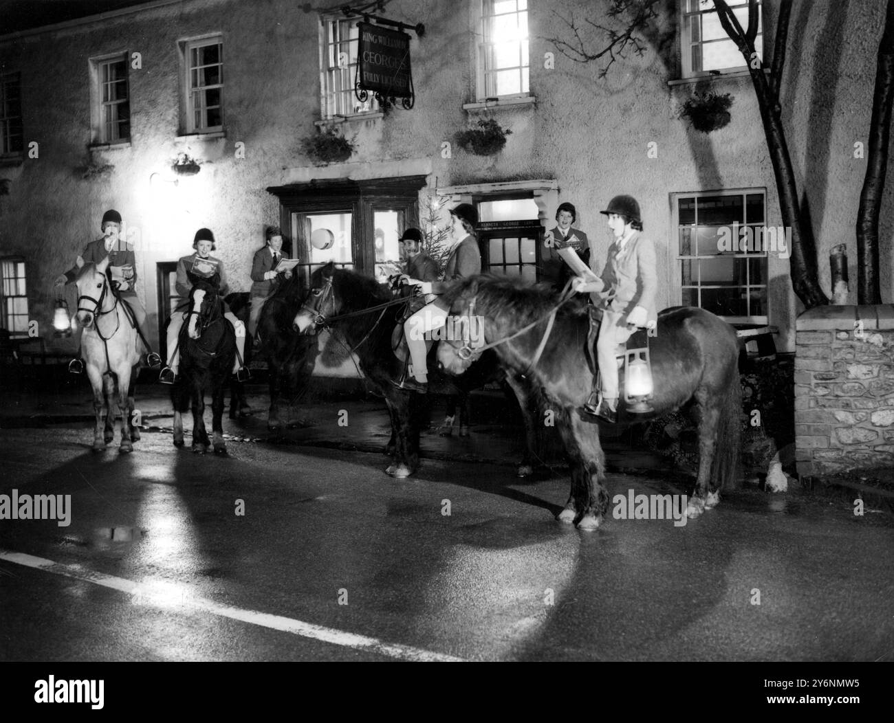 Es gibt gute Laune und gute Gemeinschaft ohne, während diese Romansänger, die auf ihren Ponys montiert sind, Weihnachtsbotschaften in die Herberge von König Wilhelm IV. In Hallen bei Bristol bringen. Die berittenen carol-Partys waren die Idee von Mrs. A D Petty, die eine örtliche Reitschule betreibt. In dieser Weihnachtszeit werden die berittenen Caroller den Bezirk besichtigen und ihren Erlös dem Winsley Chest Hospital in der Nähe von Bath in Somerset widmen. - 10. Dezember 1960 Stockfoto