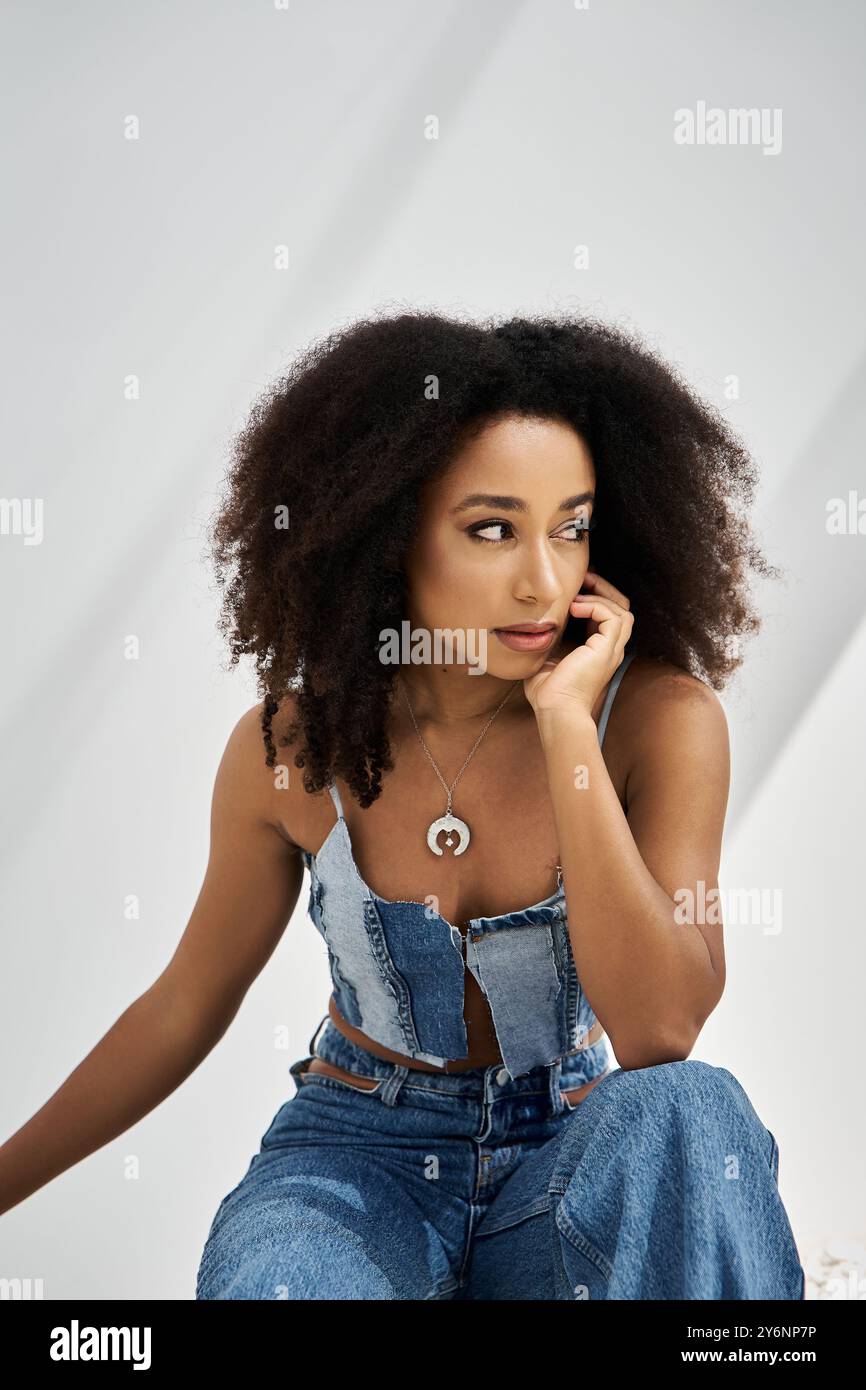 Eine stilvolle junge afroamerikanische Frau zeigt ihr trendiges Outfit in einem schicken Ambiente. Stockfoto