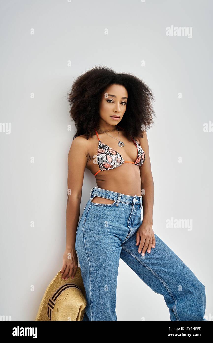 Eine schöne junge afroamerikanische Frau zeigt an einem sonnigen Tag mit Selbstbewusstsein ihren Sinn für Mode. Stockfoto