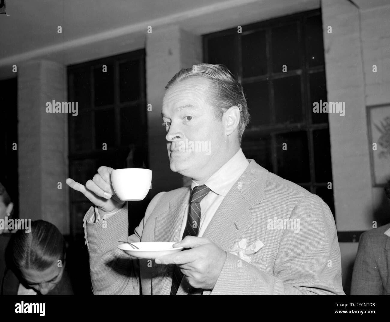 london: Bob Hope trinkt Tee während seines Besuchs in Clubland und gab dem Gründer von Rev James Butterworth ein Geschenk von 12.000 für den Wiederaufbau des Clubgeländes. 13. September 1952 Hope, Bob (orig. Leslie Townes Hope) US-amerikanischer Schauspieler und Komiker; Gastgeber oder Co-Moderator der Academy Awards Ceremony achtzehn Mal 1939-1977; mit Bing Crosby, Co-Hauptrolle in sieben Road-Filmen 1940-1962; bekannt für Überseetouren, die US-Truppen unterhielten, vor allem zu Weihnachten, beginnend 1941; Mitverfasste Memoiren mit „Don't Shoot, IT's Only Me“ 1990; vom Kongress 1997 ernannt wurde er zum Ehrenveteranen ernannt (nur US).  1903-200) Stockfoto