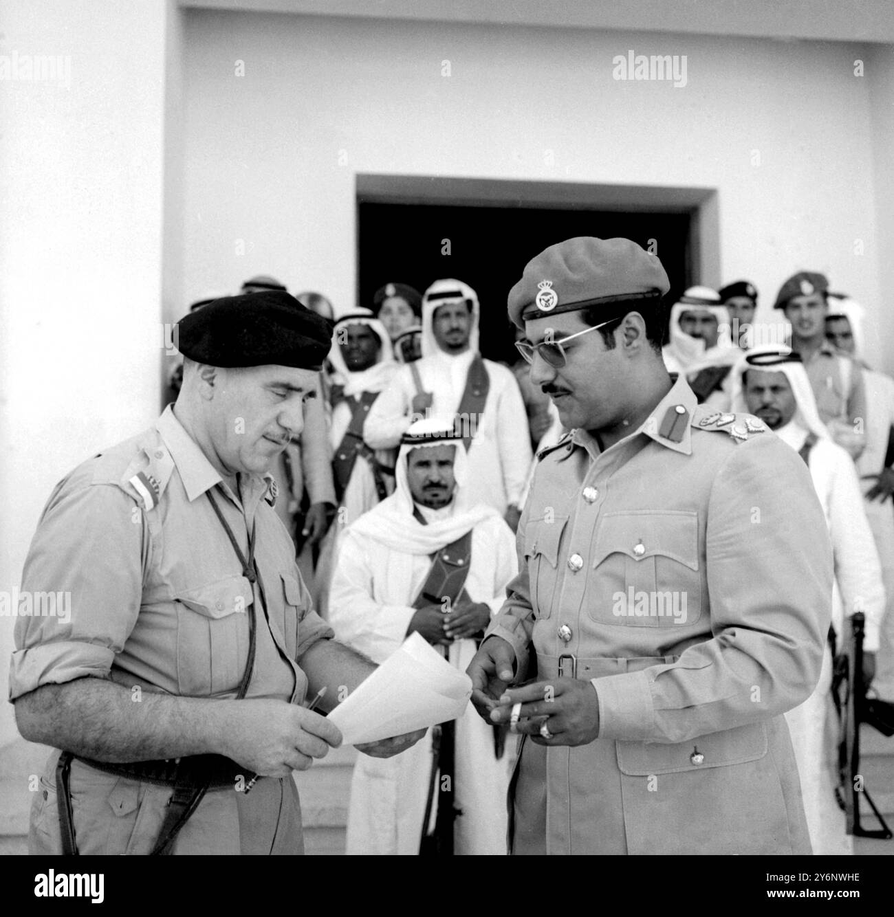 Kuwait: Mit Shiekhs im Hintergrund spricht Brigadier Moubarek El Abdullah El Jaber Sabah (29) rechts mit einem britischen Armeeoffizier im Hauptquartier. 9. Juli 1961 Stockfoto