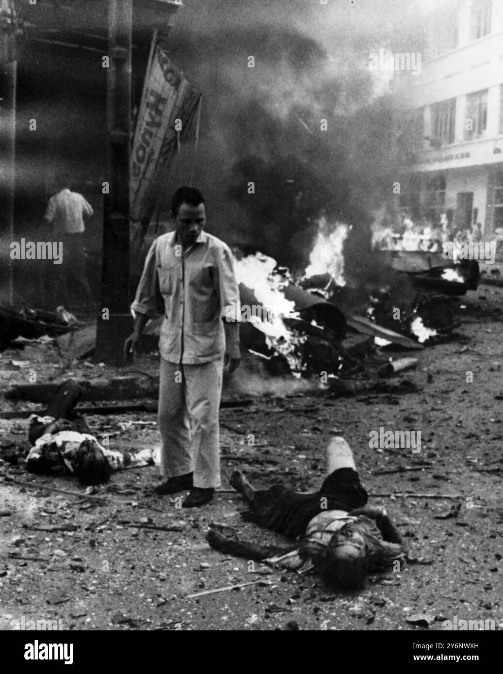 Terrorexplosion US-Botschaft Saigon kommunistische Terroristen haben letzte Woche vor der US-Botschaft eine Explosion ausgelöst und das Gebäude und andere in der Nähe zerstört. Auf diesem Bild sieht ein entsetzter Vietnamese Tote und Verletzte auf der Straße vor der Botschaft, wo unschuldige Passanten durch die Explosion niedergeschlagen wurden. April 1965 Stockfoto