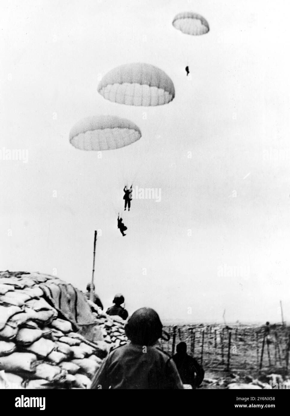 Schwere Kämpfe um die französische Festung in Indochina der anfängliche Angriff der Viet Minh, die isolierte französische Festung Dien Bien Phu zu Spalten, scheiterte, aber in Indochina wird immer noch von bitteren Kämpfen berichtet. Die Franzosen haben schwere Verluste an den Rebellen erlitten. Frankreichs dringendster Bedarf ist derzeit die Wiederaufforstung von Flugzeugen. Seit dem gewaltsamen Aufbrechen erhält die Garnison Ersatz, Männer und Material durch Fallschirme. Foto zeigt: Dringend benötigte Verstärkung kommt an. Den Fallschirmjägern wurde die Benutzung von zwei Flugstreifen in Dien Bien Phu verweigert, die frühzeitig außer Betrieb gesetzt wurden Stockfoto