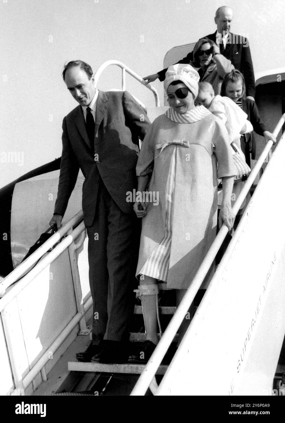 Nachdem sie drei Schläge im Februar überlebt hatte, wird die Schauspielerin Patricia Neal (39), die mit dem Acadamy-Preis ausgezeichnet wurde, als sie die Stufen eines transweltbeweglichen Boeing-Jets nach dem Einflug aus Los Angeles herunterkam. Mit ihrem Ehemann, dem britischen Schriftsteller Roald Dahl und ihren drei Kindern (zwei sind hier zu sehen). Zwei Kindermädchen reisten auch mit der Familie. Sie trug einen schwarzen Fleck über ihrem linken Auge und eine Stahl- und Lederstütze auf ihrem rechten Bein. Die in Amerika geborene Patricia, die im August ein Baby erwartet, wurde durch die Schlaganfälle teilweise gelähmt und fällt in ihrer Rede immer noch aus Stockfoto